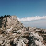 gray rocky mountain near body of water during daytime