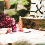 picnic basket beside two Ezze bottles on blanket