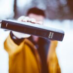 person holding Holy Bible